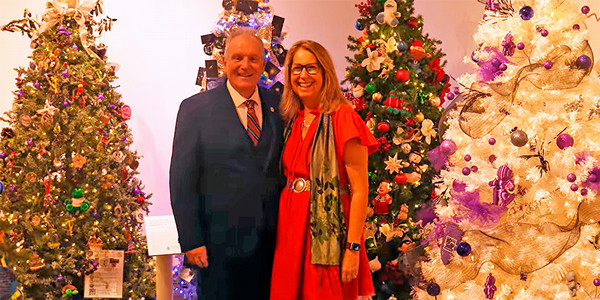 President Blake and his wife in front of Christmas Trees